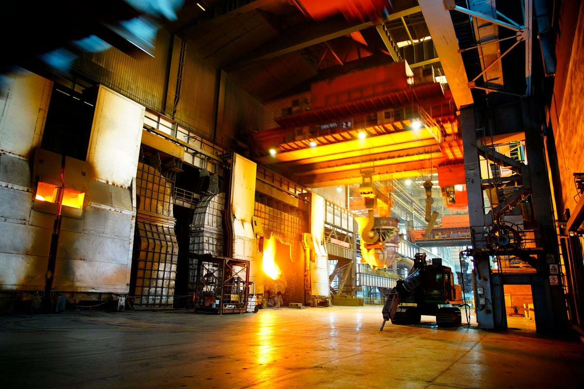 High temperature forging in iron and steel plant with heavy industrial machinery in workshop